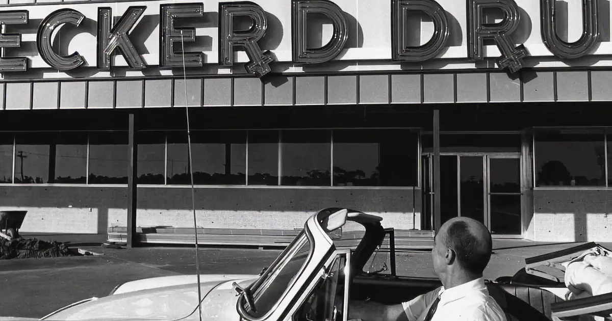 Eckerd Drugs store with "You'll Love to Shop Your" sign, classic cars, and people walking.