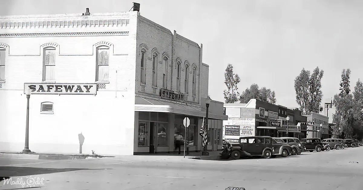 A vintage Safeway store corner building with classic cars parked in front, under a cloudy sky.