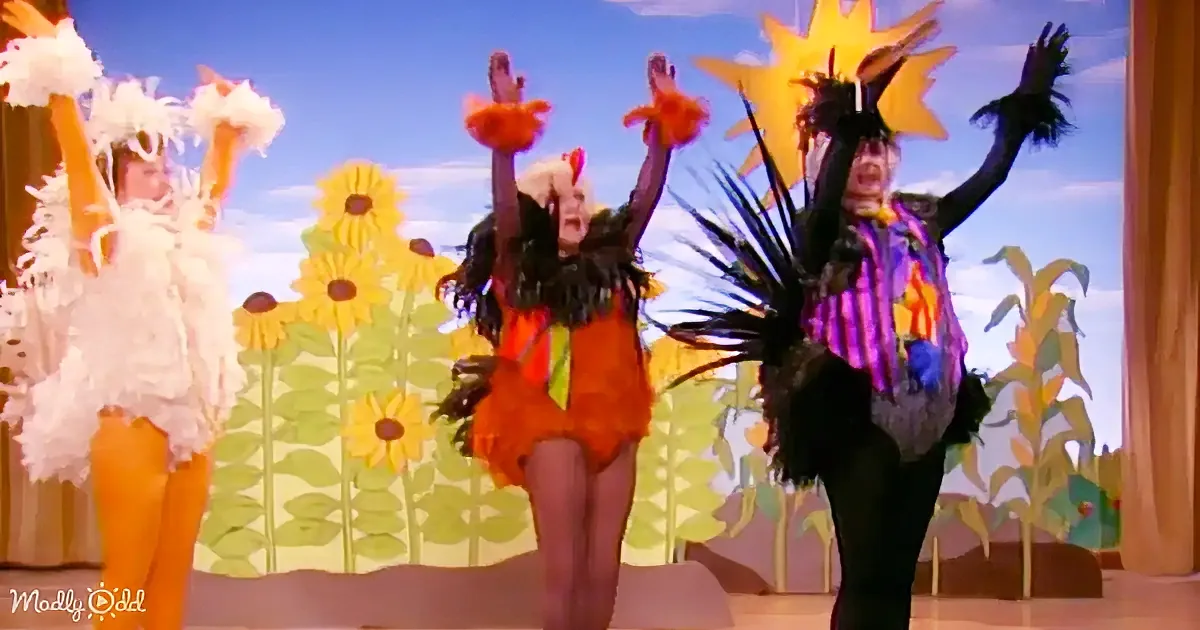 Three performers in vibrant costumes dance joyfully against a sunflower backdrop.