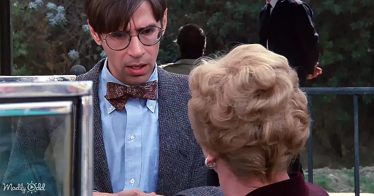 A man in a bow tie and blazer is talking to a woman with blonde hair.
