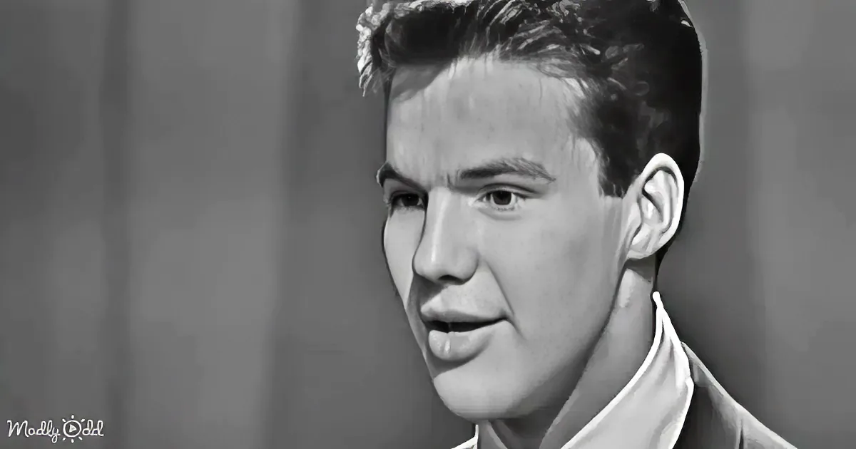 A man with short, styled hair and a white shirt is shown in a close-up, looking slightly to the side.