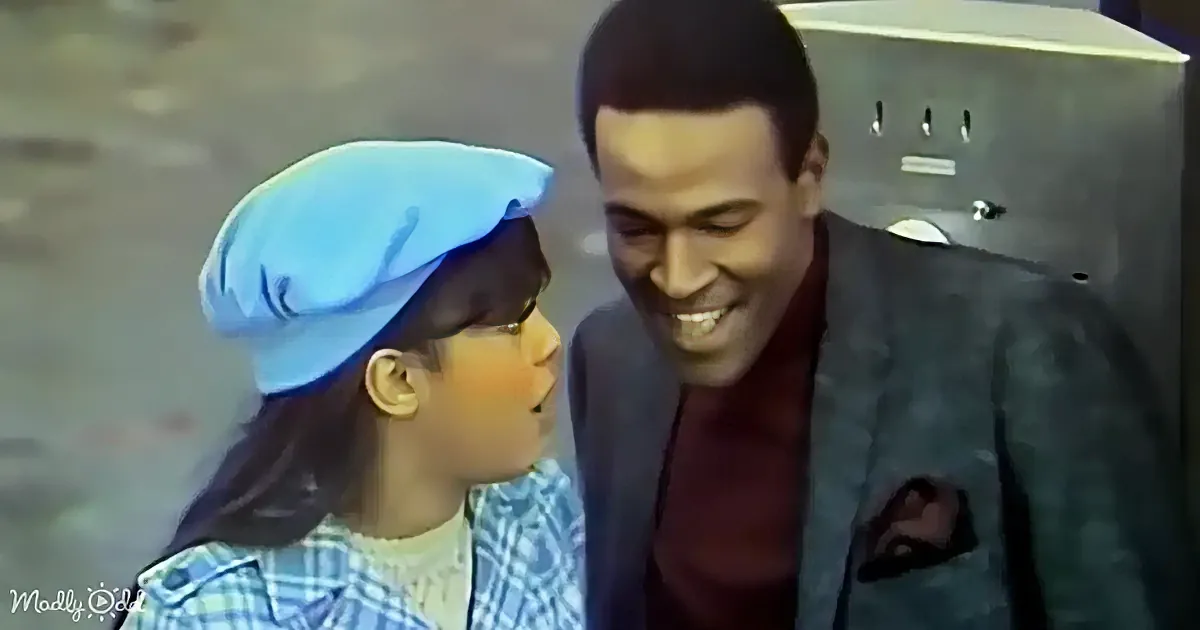 A young girl in a blue hat and plaid shirt smiles at a man in a suit, both appearing happy.