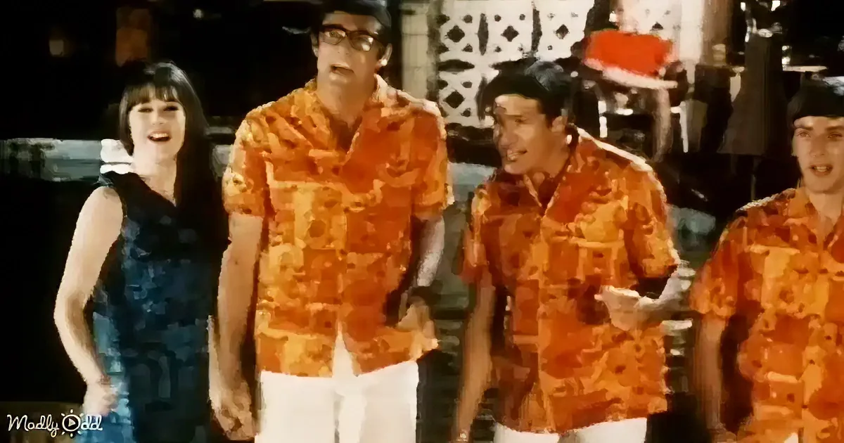 A group of people in vibrant orange patterned shirts stands together, smiling and posing.