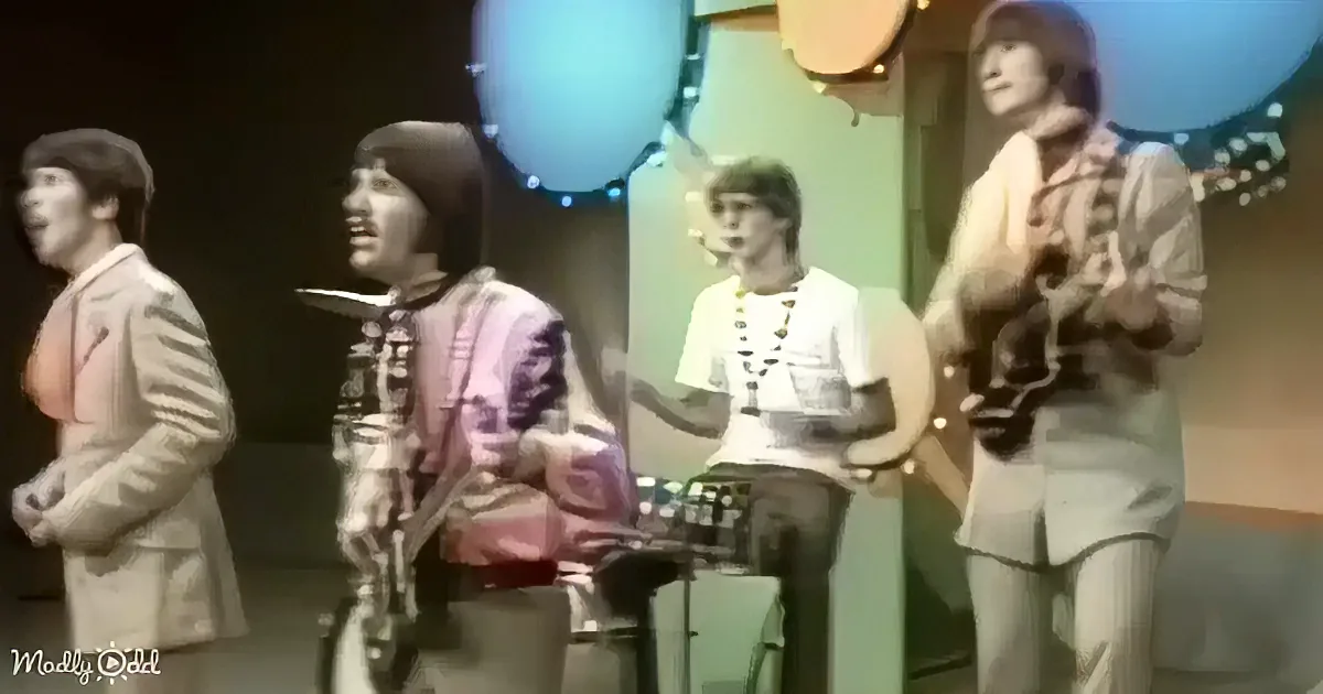 A group of musicians, including a drummer and guitarist, perform on stage with colorful lighting.