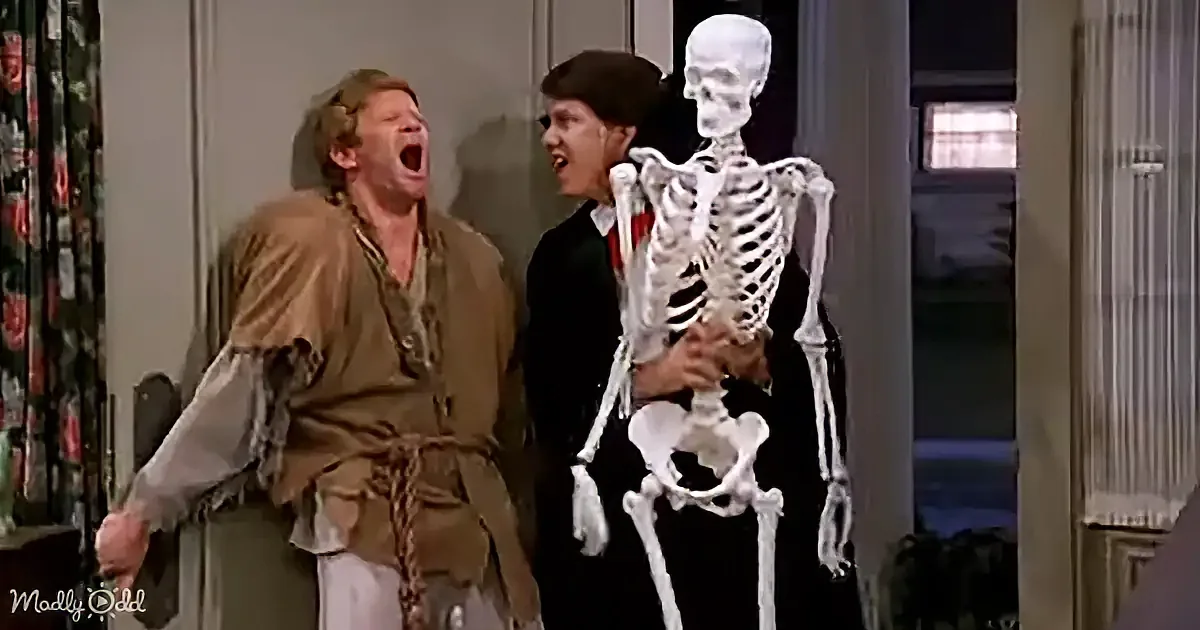A man in a pirate costume yells next to another man holding a skeleton.