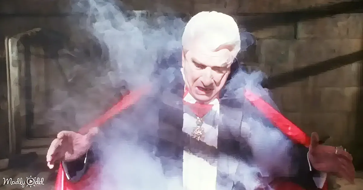 An elderly man in a red cape and white shirt is surrounded by smoke, holding a red wand.