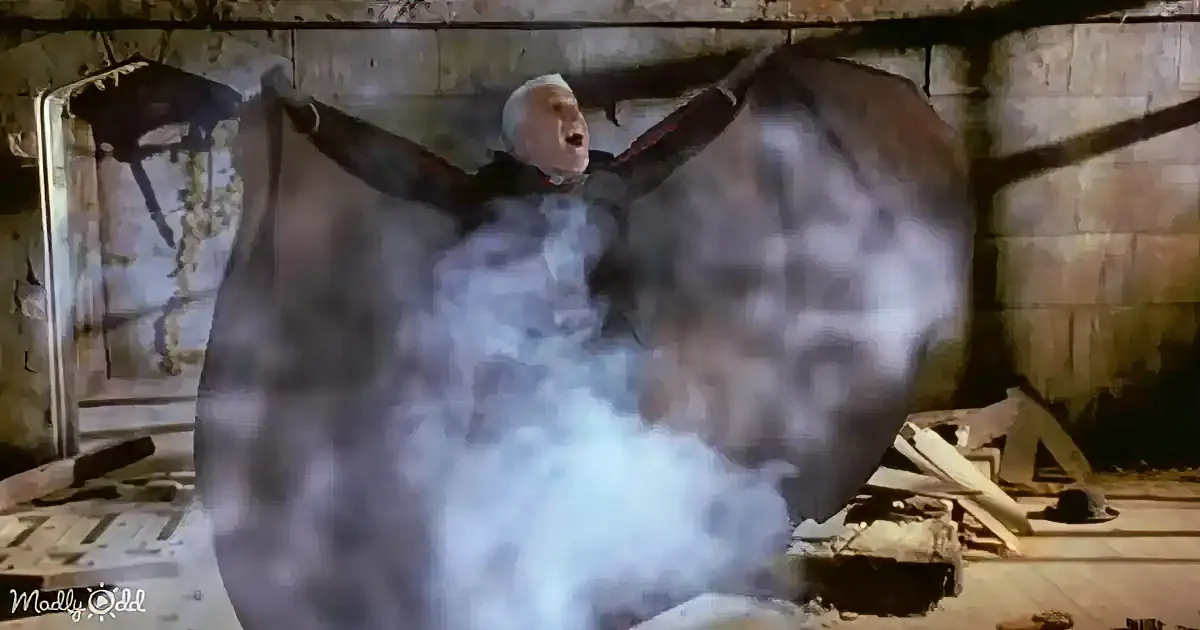 A man in a dark outfit with outstretched arms is surrounded by a cloud of smoke in a dilapidated room.