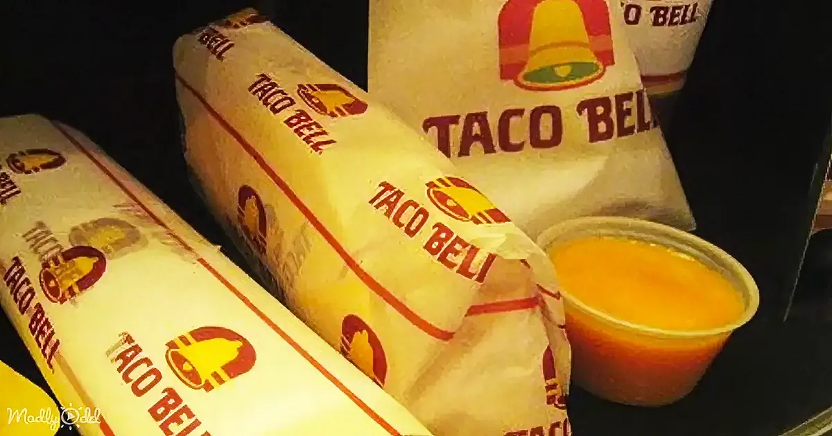Taco Bell wraps and a small cup of orange sauce are prominently displayed.