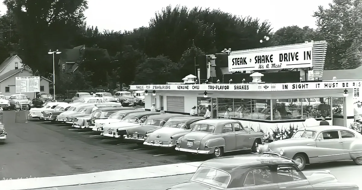 A Steak 'n Shake Drive-In with classic cars lined up for service.