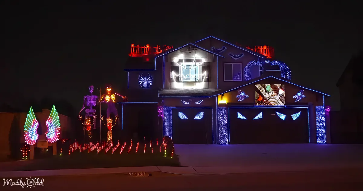 A house adorned with Halloween lights, skeletons, and spooky decorations, creating a festive and eerie atmosphere.