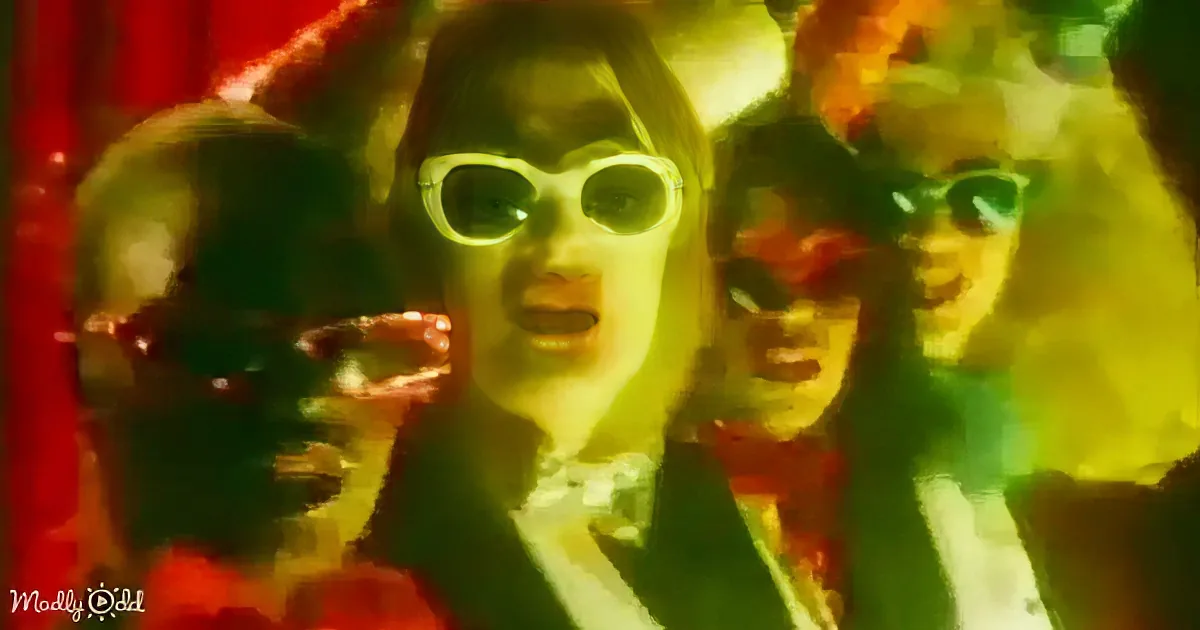 A group of people wearing sunglasses, one holding a microphone, in a vibrant, colorful setting.
