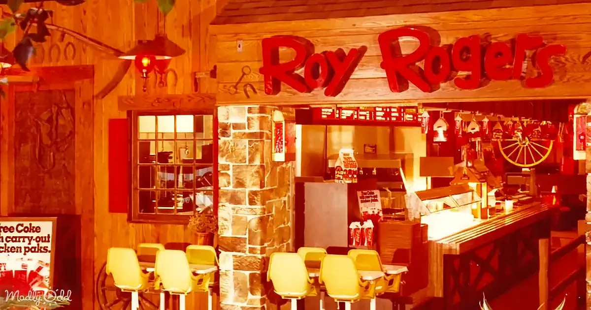 Roy Rogers restaurant interior with wooden decor, red signage, yellow chairs, and stone pillar.