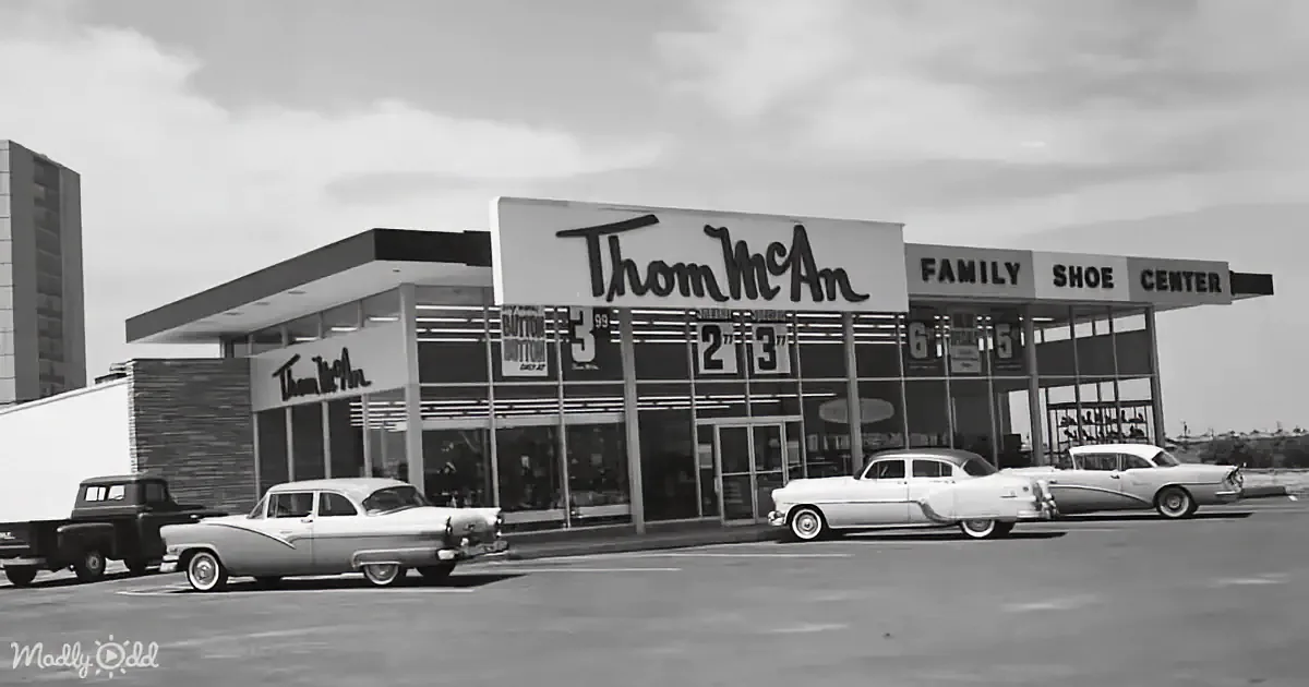 Thom McAn Family Shoe Center with vintage cars parked in front, black and white photo.