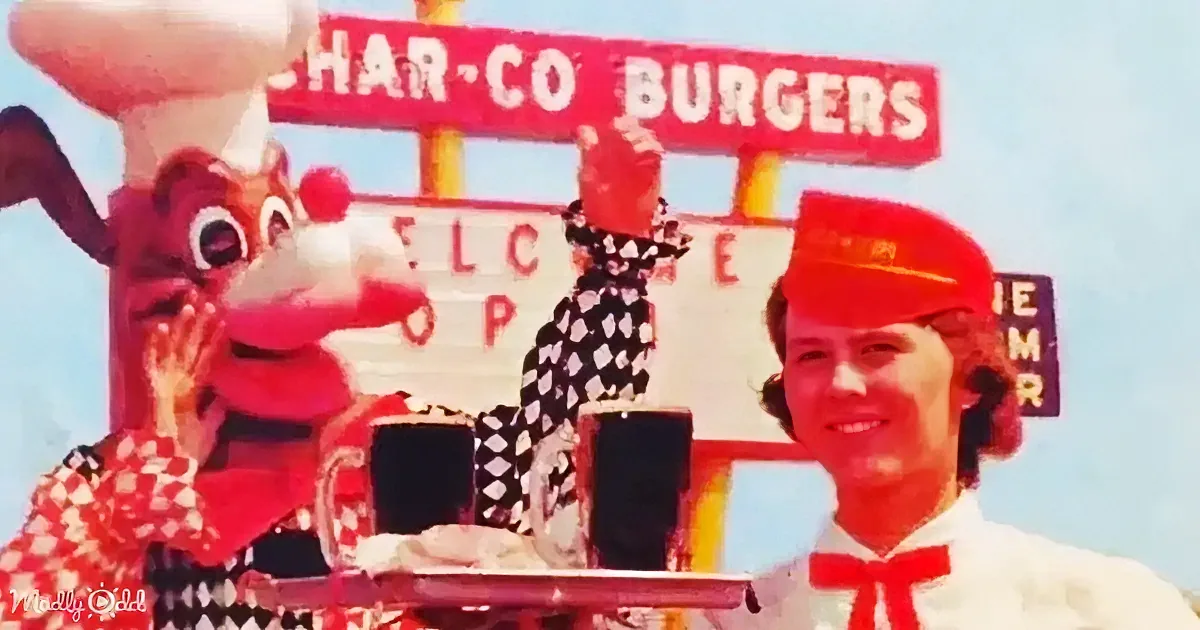 A person in a red uniform holds a tray with food, next to a pink mascot and a sign for Char-Co Burgers.