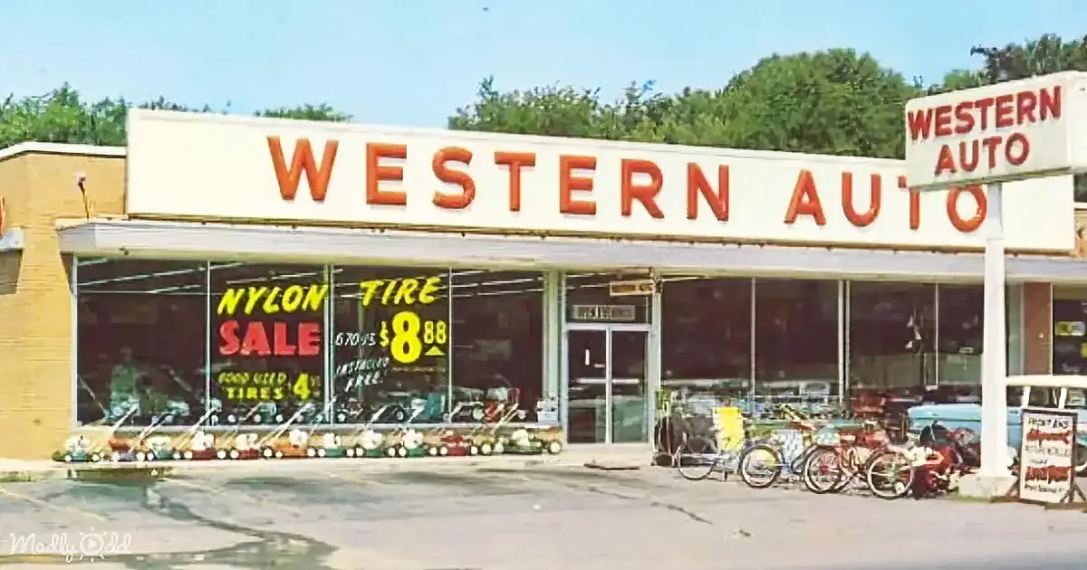 Western Auto store with "Nylon Tire Sale" sign, bicycles, and vintage cars outside.
