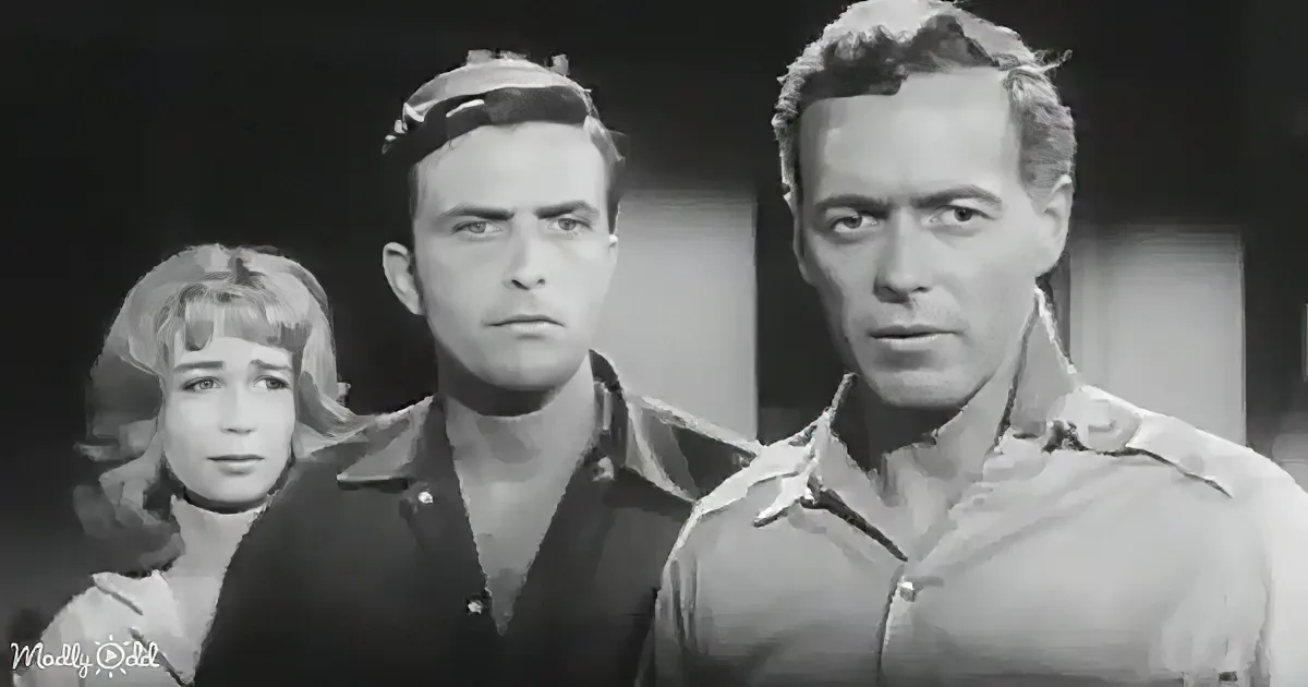 A man in a military uniform stands next to another man in a dark shirt, with a woman in the background.