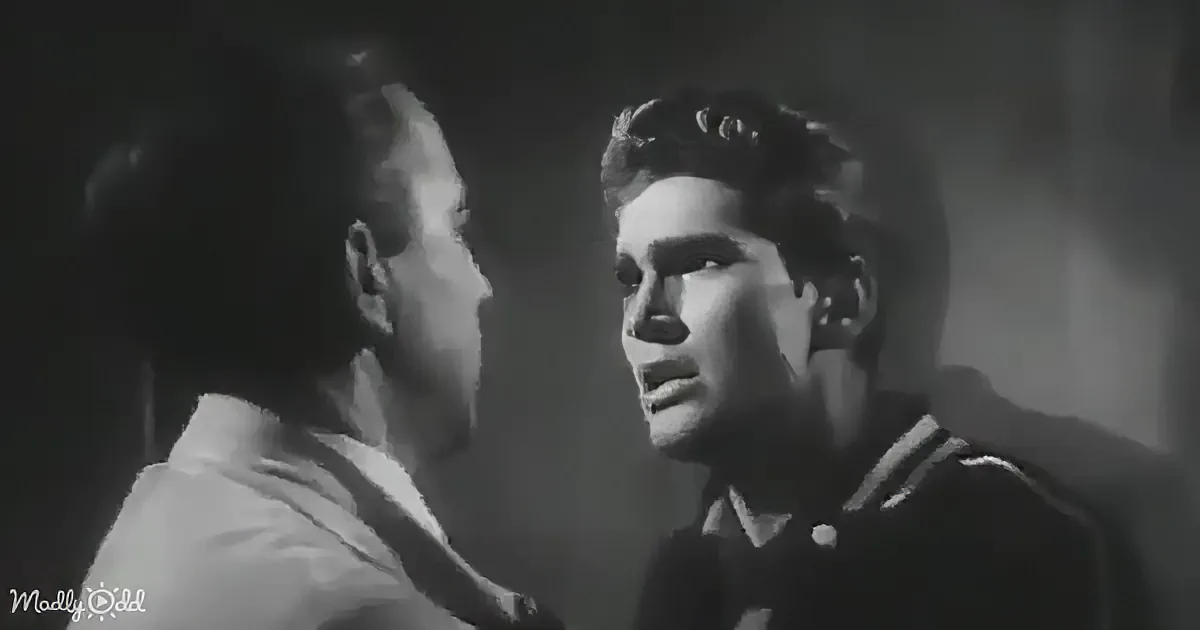 A man in a white shirt is holding another man in a dark shirt, both in a tense moment.