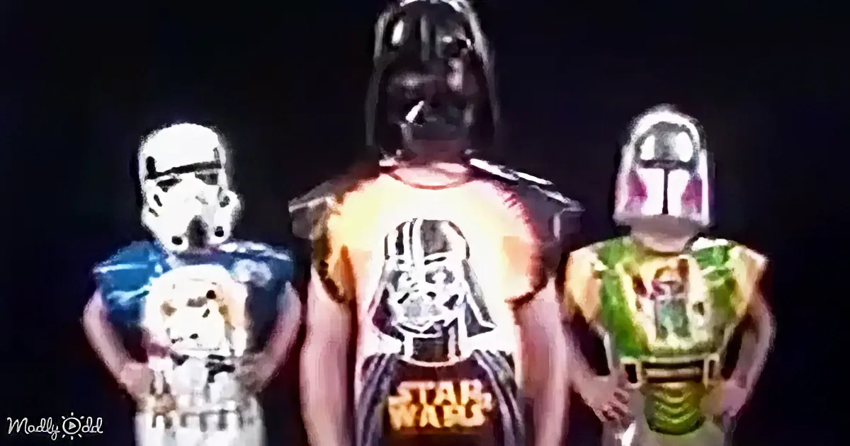 A person in a Darth Vader costume stands between a Stormtrooper and Boba Fett, all wearing Star Wars-themed jerseys.