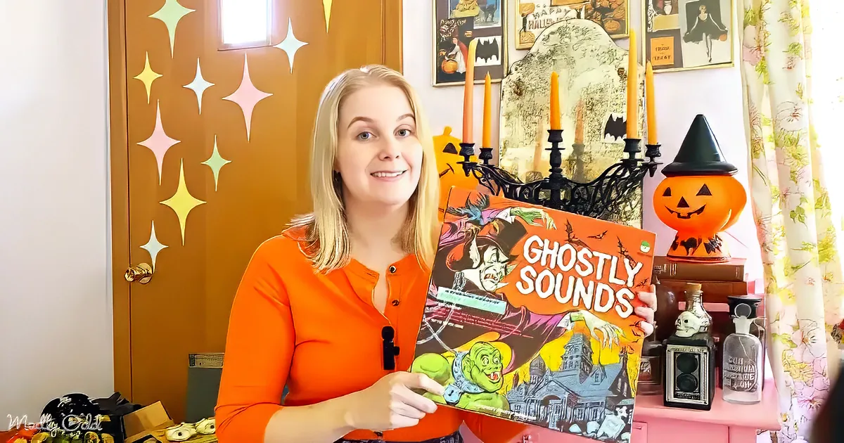 A woman in an orange shirt holds a "Ghostly Sounds" album, surrounded by Halloween decorations.
