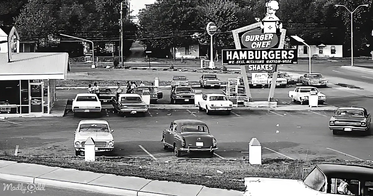 Burger Chef sign advertises hamburgers and shakes in a busy parking lot with vintage cars.