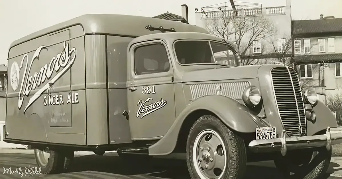 A vintage delivery truck for Vernor's Ginger Ale is parked on a street, showcasing its classic design and branding.