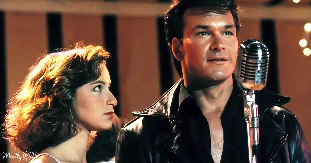 A man in a leather jacket sings into a microphone, accompanied by a woman in a dress.