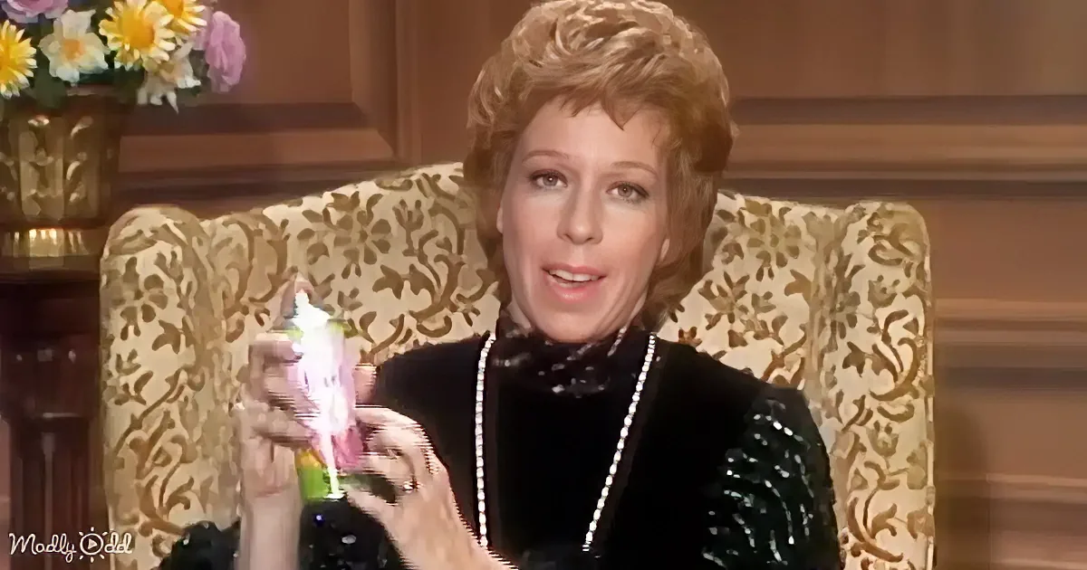 A woman in a black sequined dress sits in a floral-patterned chair, holding a colorful object.