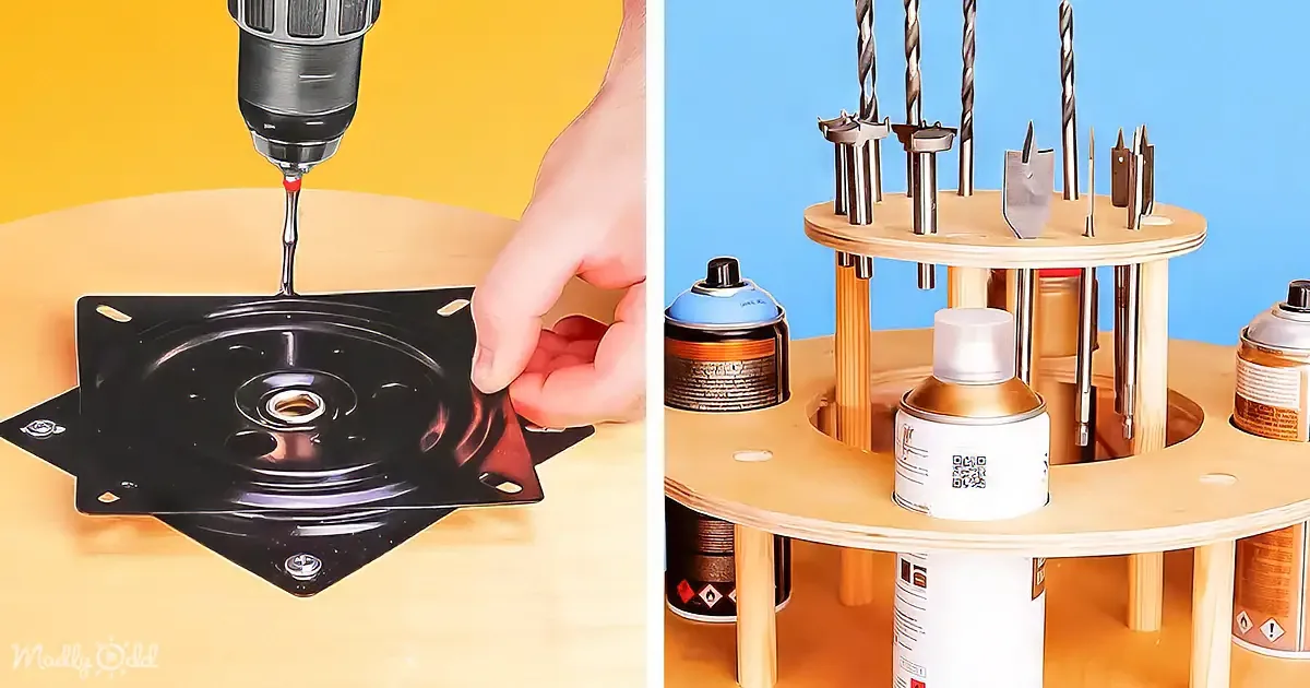 A hand holds a black metal plate while a drill bit is about to drill into it, with a wooden tool organizer in the background.