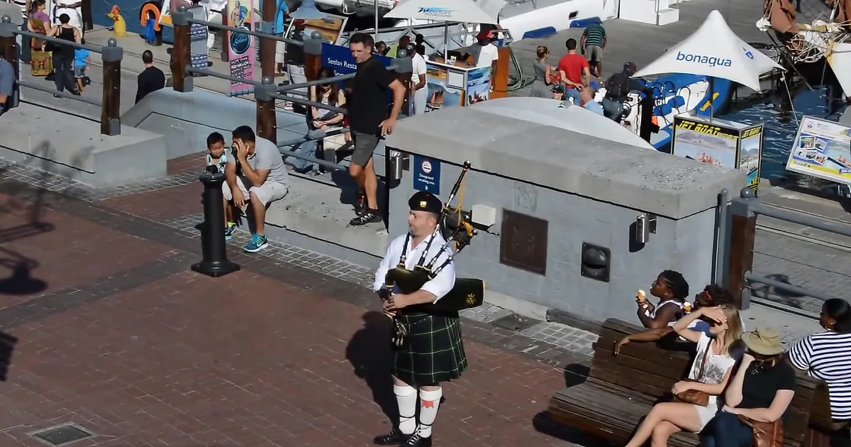 Man Plays Bagpipes and a Crowd Gathers as Pipers Join In