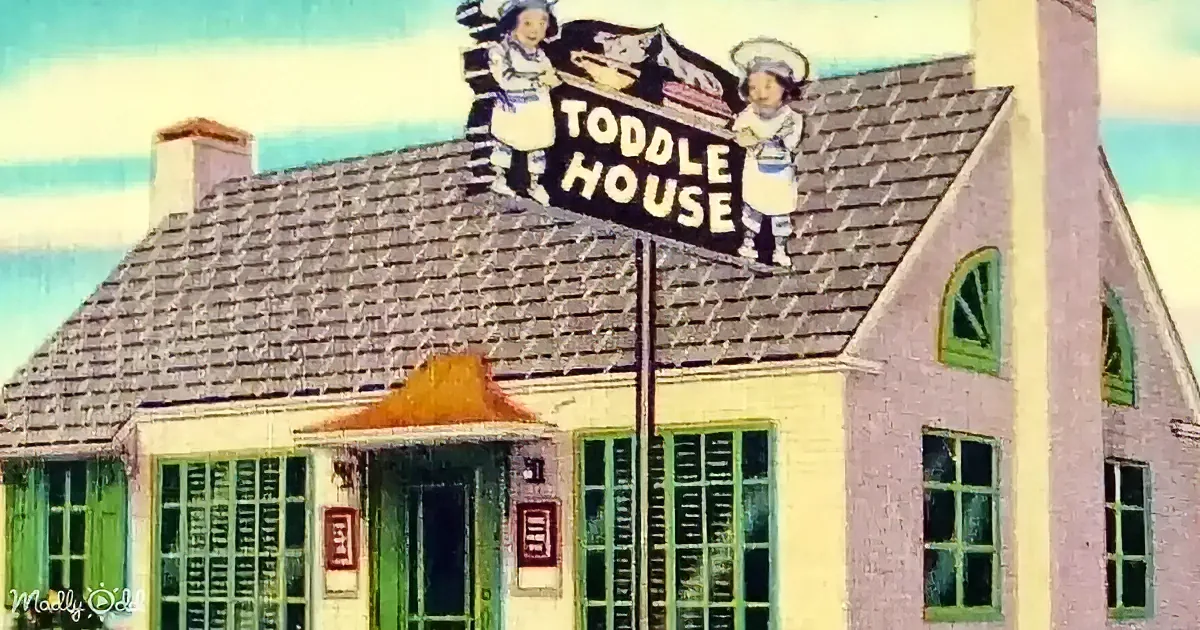 A vintage sign for "Toddy House" featuring chefs and food imagery atop a white building.