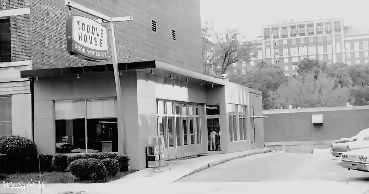 A vintage black-and-white photo shows a "Toddl House" restaurant with a sign, large windows, and a parking lot with...