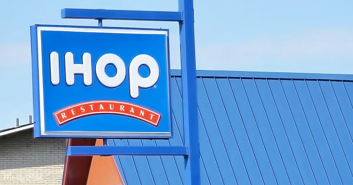 A blue IHOP restaurant sign with white lettering and a red arch is prominently displayed.