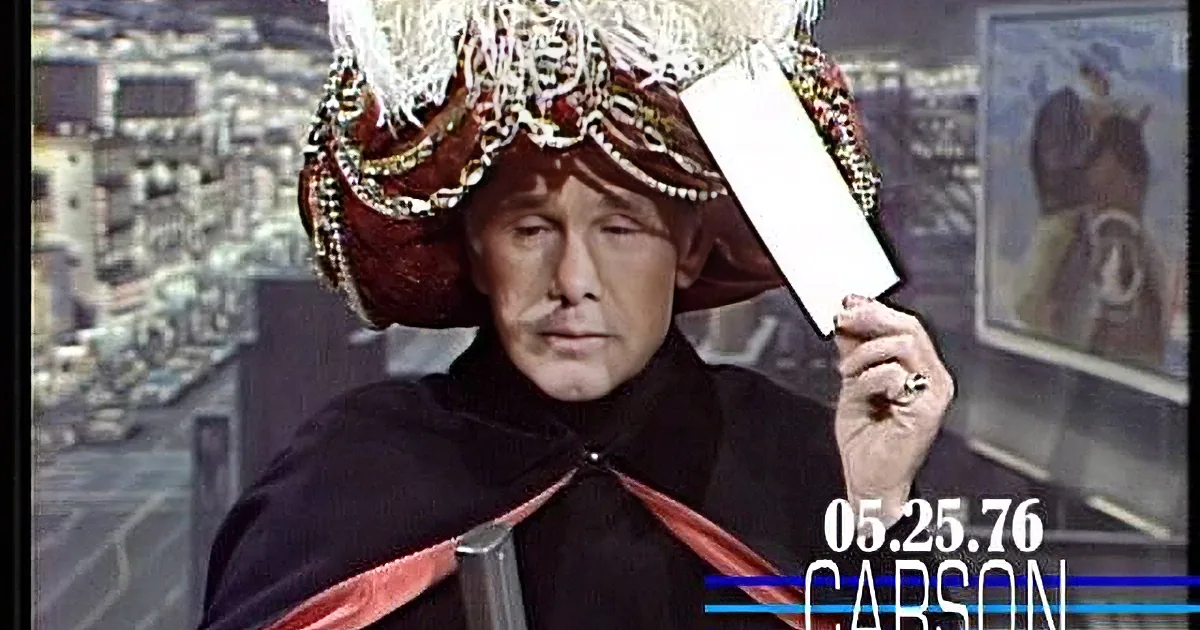 A person in a red and black costume with a large, ornate hat holds a white object, set against a cityscape background.