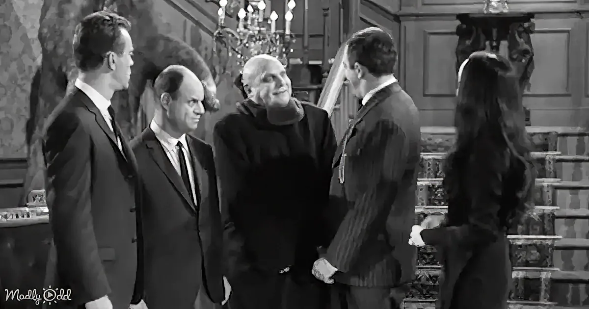 A man in a black robe stands with four others in formal attire in a grand, ornate room.