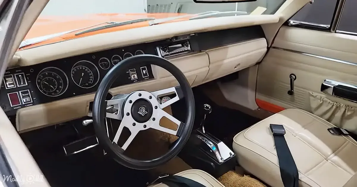 A vintage car's interior with a black steering wheel, beige seats, and a dashboard featuring analog gauges and a radio.