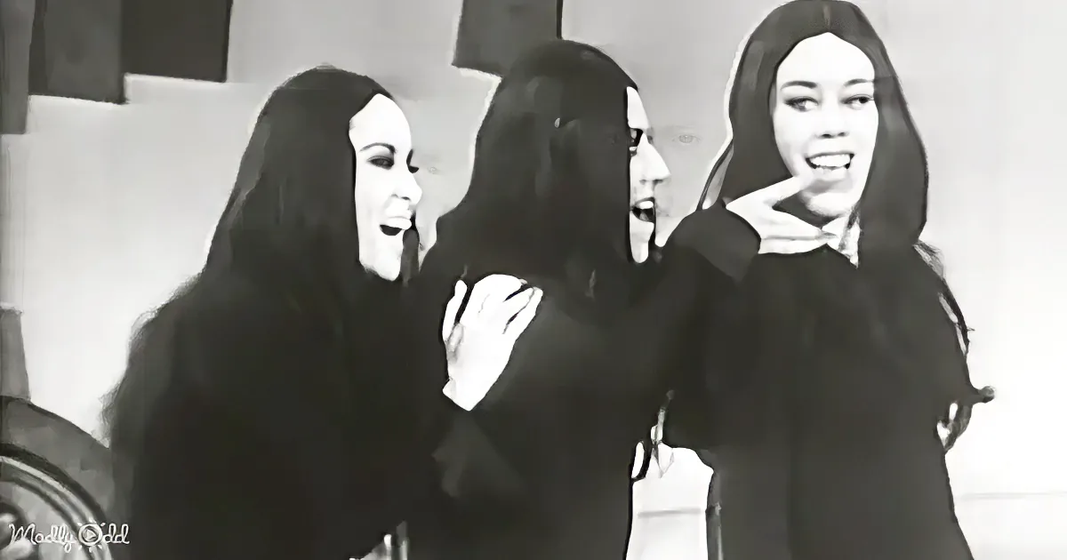 Three women in black attire, possibly nuns, are engaged in a conversation or interaction.