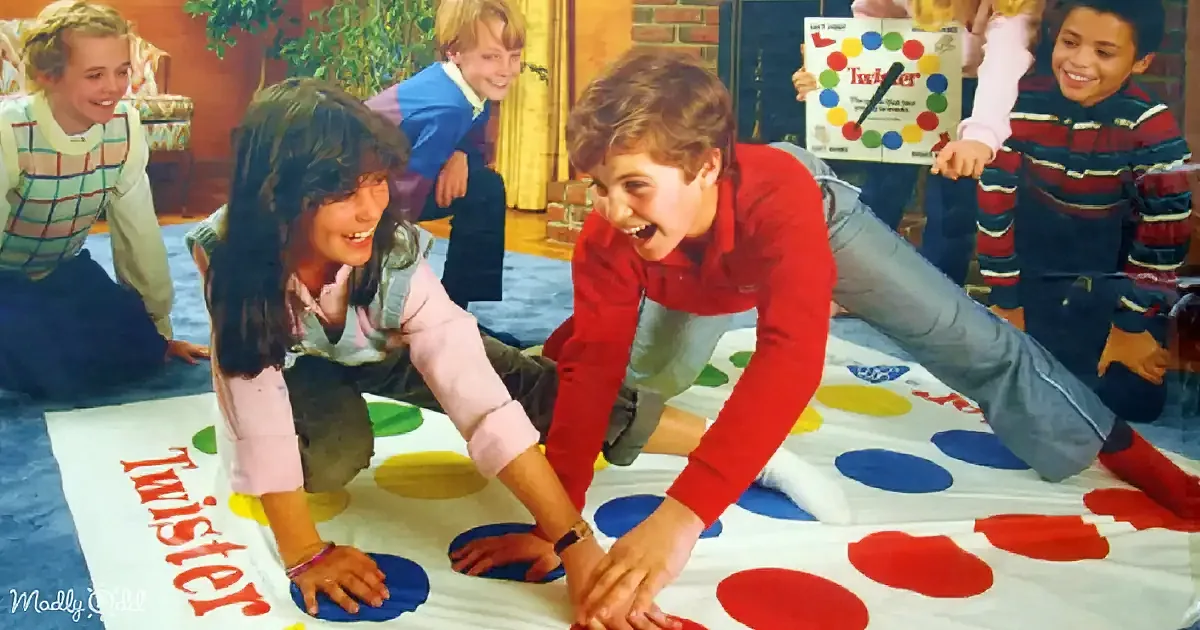 Children play Twister on a colorful mat, laughing and enjoying the game.