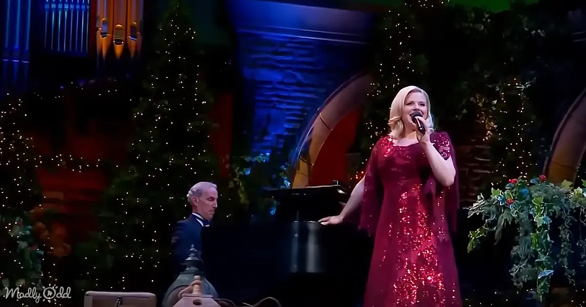A woman in a red sequined dress sings into a microphone on stage, accompanied by a pianist.