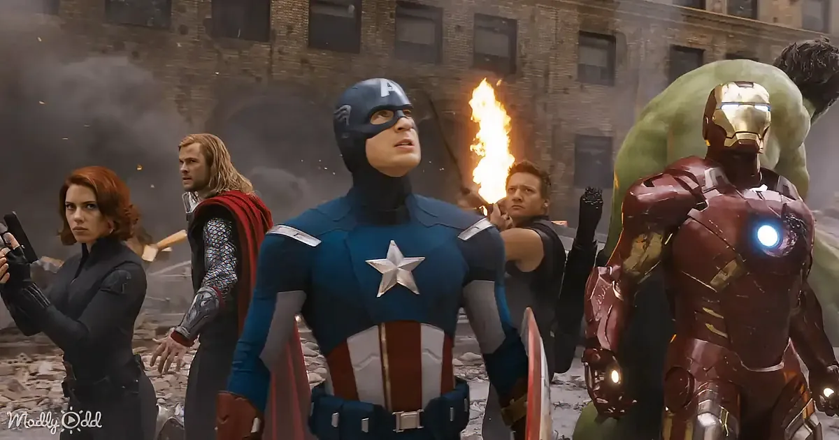 Captain America leads a group of superheroes, including Iron Man and the Hulk, in a battle scene amidst rubble and fire.