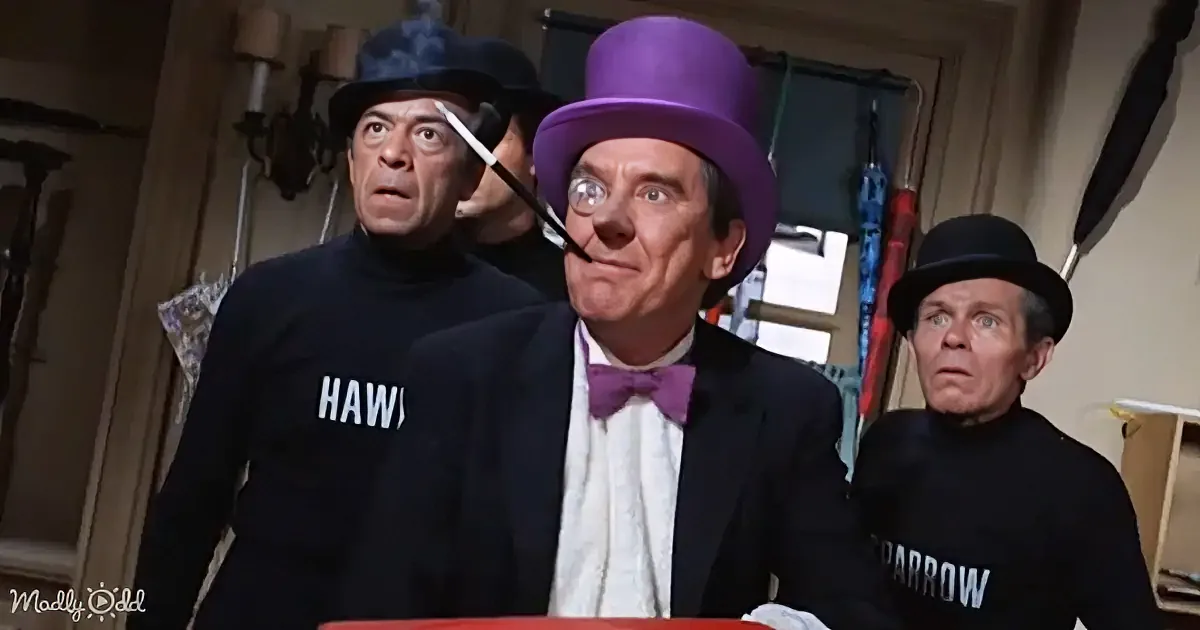 A man in a purple top hat and bow tie smokes a pipe, flanked by two men in black sweaters with "HAWK" and "SPARROW"...