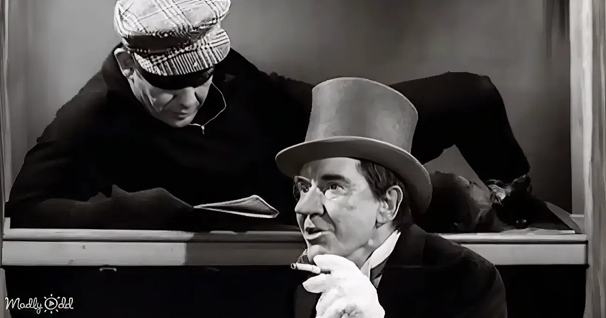 A man in a top hat smokes a cigarette while another leans over a desk, both in a vintage setting.