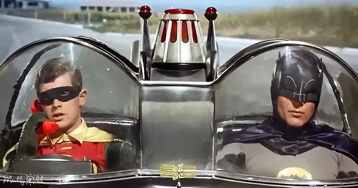 Batman and Robin in their iconic car, driving with a futuristic design.