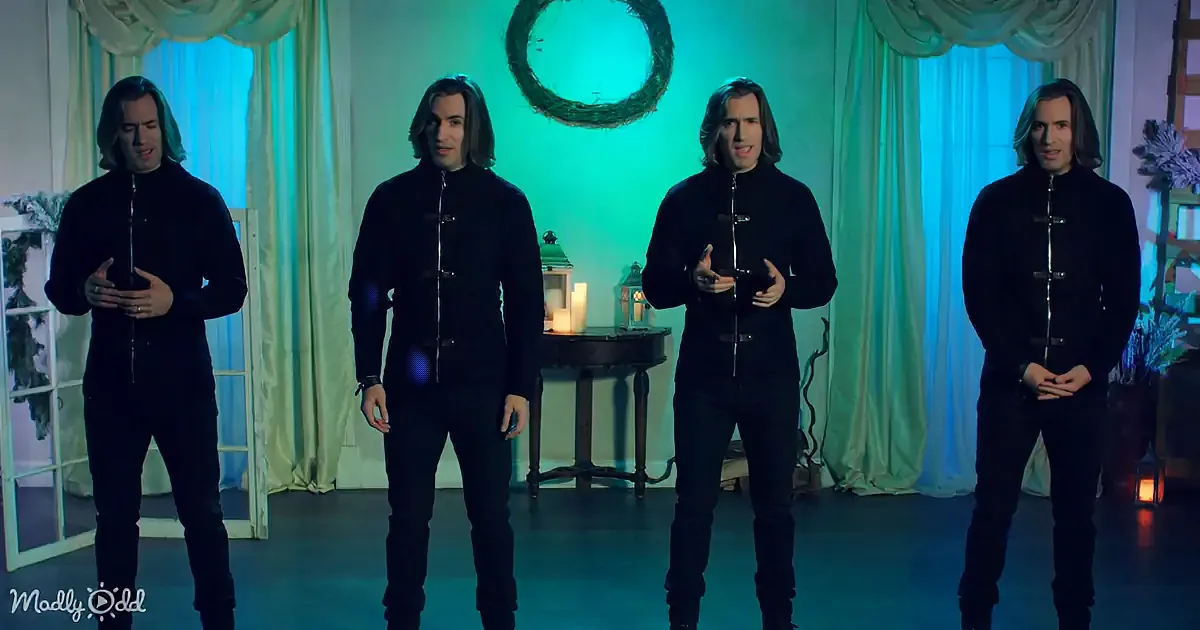 Four identical men in black stand in a room with teal lighting, green curtains, and a wreath.