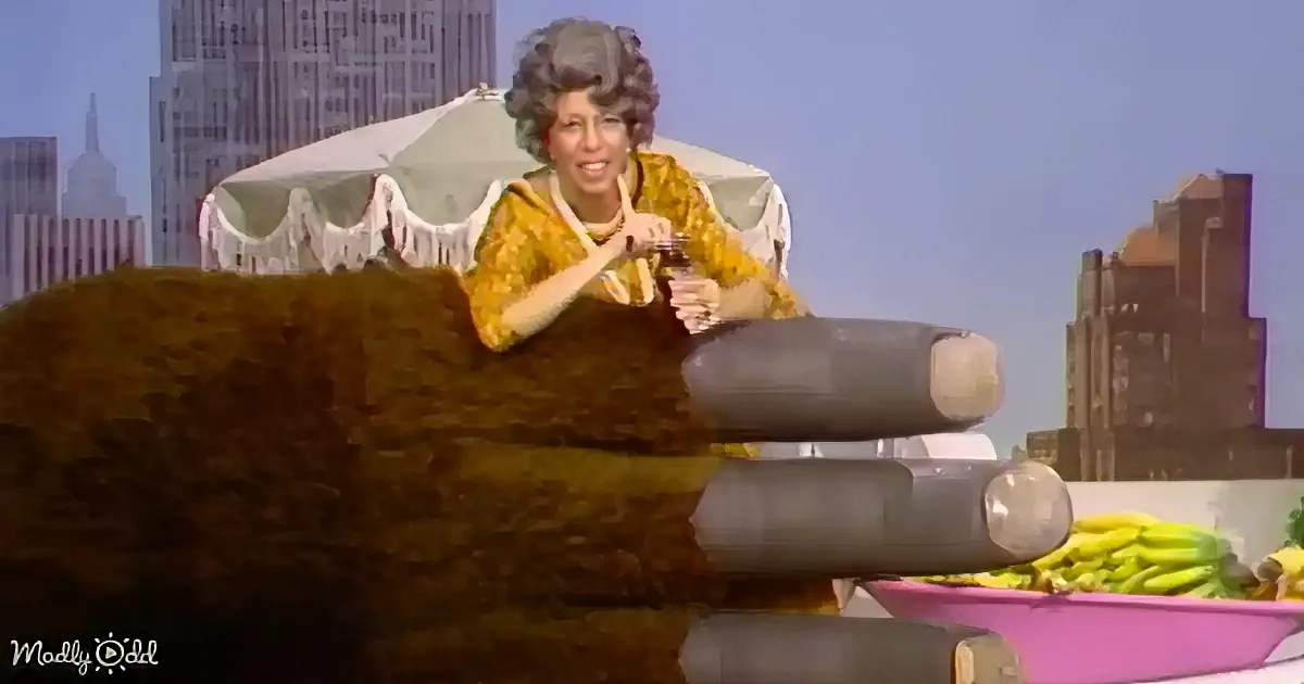 A person in a yellow floral dress sits on a large, furry object with a cityscape and bananas in the background.
