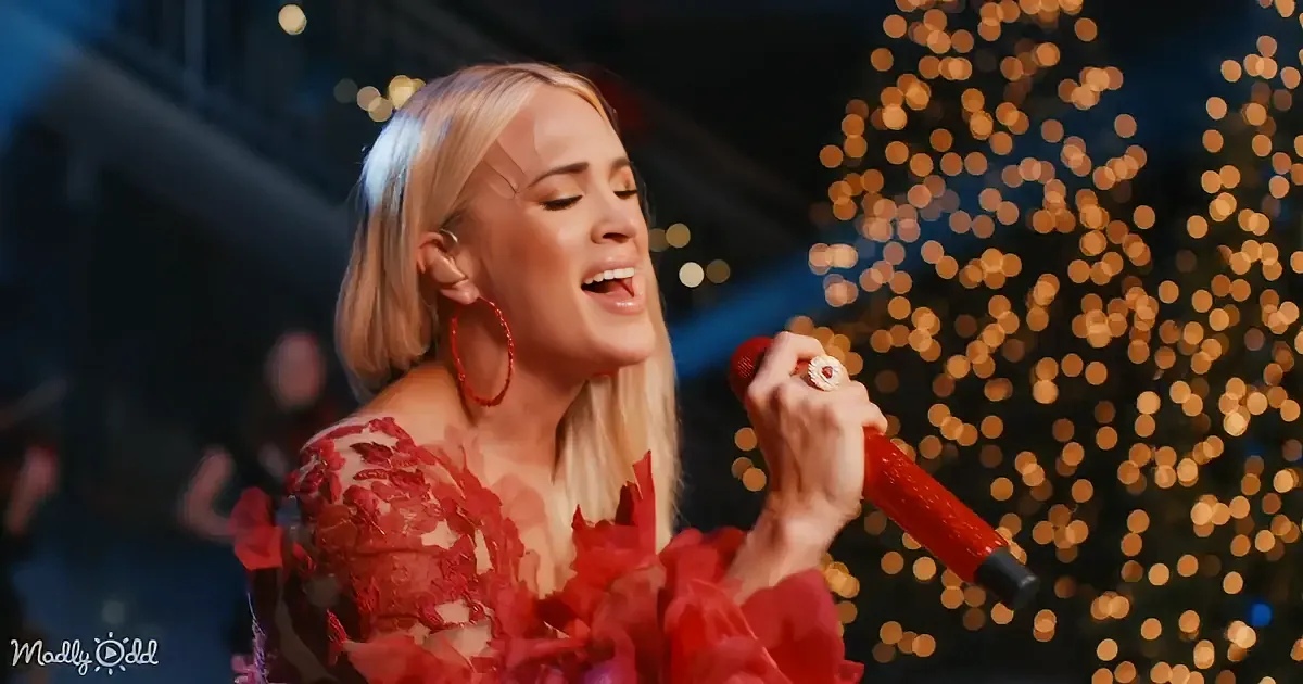 A woman in a red dress sings into a red microphone, surrounded by blurred lights.