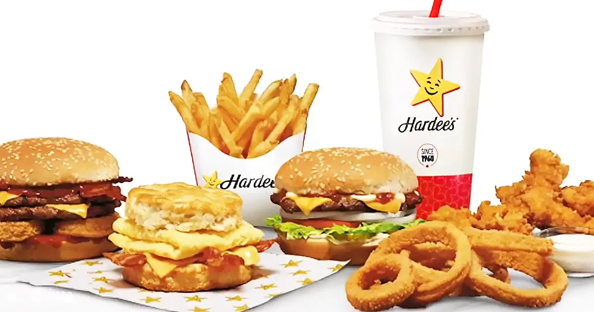 Hardee's meal featuring burgers, fries, onion rings, biscuits, and a drink with a smiley star logo.