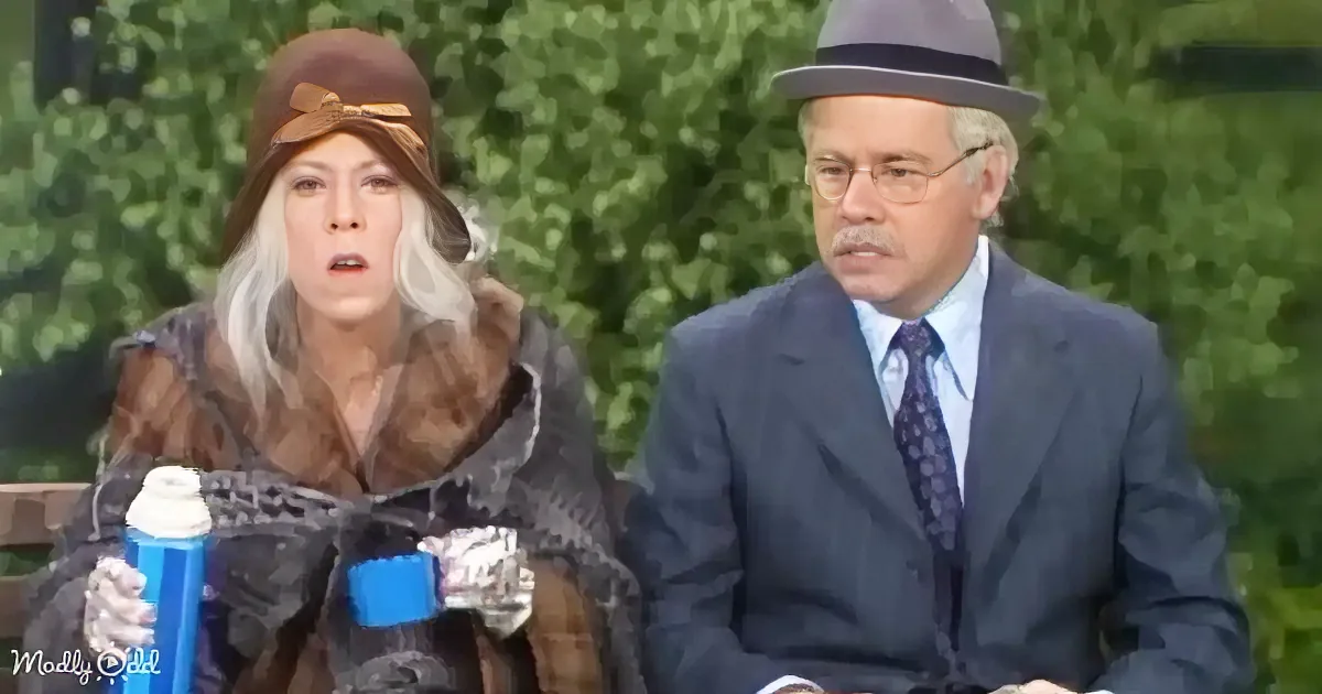 A woman in a fur coat and hat holds a can, while a man in a suit and hat sits beside her.
