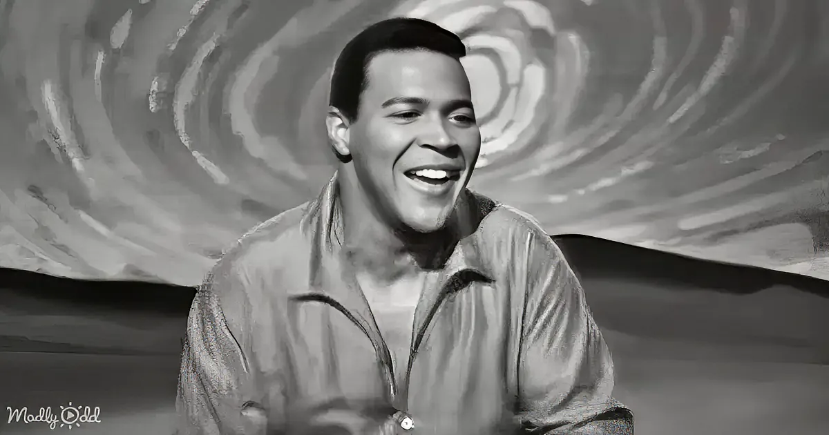 A smiling man in a button-up shirt against a swirling background.