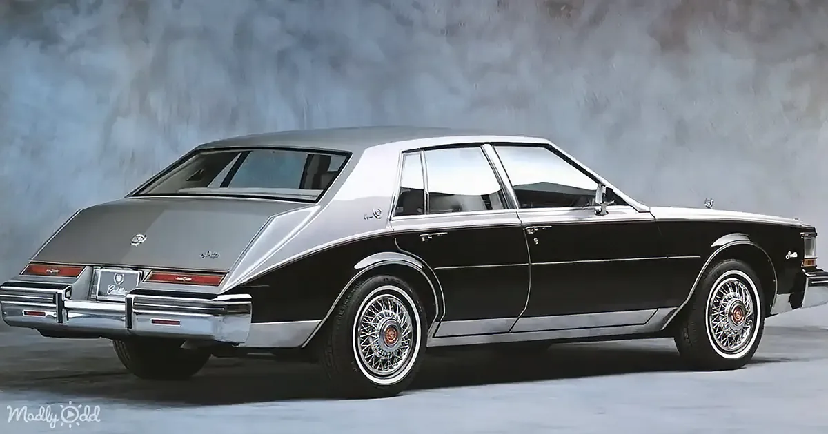 A classic black Cadillac with silver accents and wire wheels is displayed against a textured background.