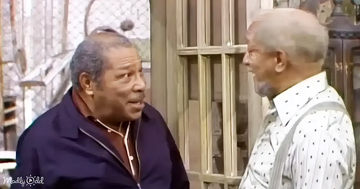 Two older men are engaged in conversation, one wearing a dark jacket and the other a white shirt with black dots, in a...